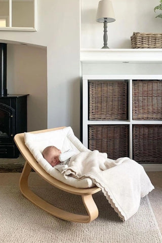 Sleeping Baby in Rocker under a scalloped edge Organic Cotton Baby Blanket 