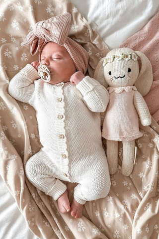 Sleeping Baby wearing Moss Stitch Baby Romper with Dummy, bow headband and bunny toy