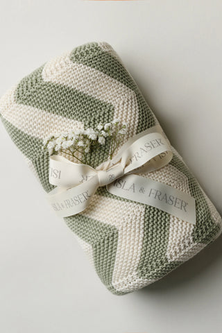 Sage and Cream Chevron Baby Blanket tied with a ribbon with a sprig of gypsophilia