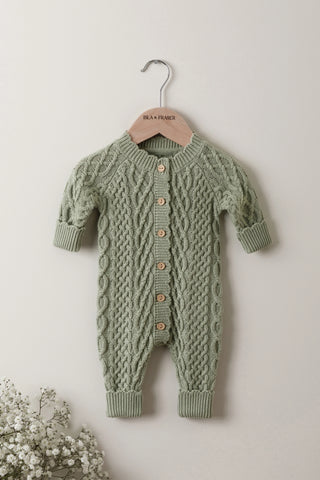 Sage cable knitted baby romper on a wooden Isla & Fraser hanger