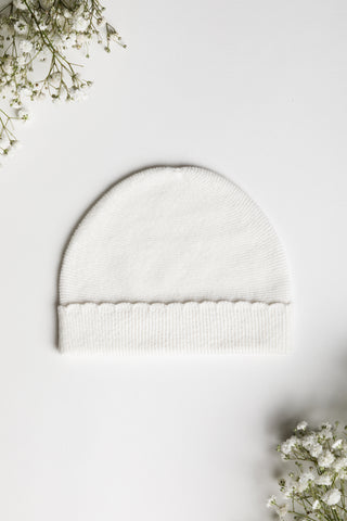 white knitted baby hat on white background