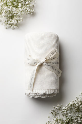 White nitted baby blanket on white background tied with an Isla & Fraser ribbon