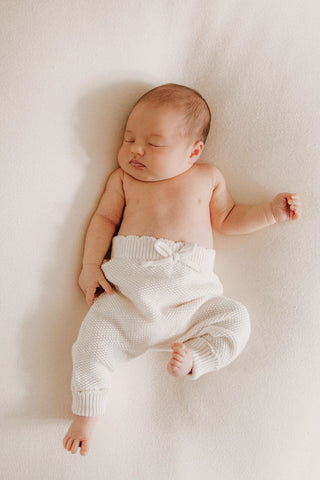 Sleeping baby wearing knitted bow baby trousers