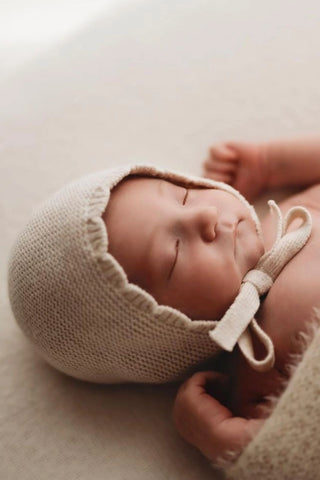 Sleeping newborn baby wearing knitted bonnet
