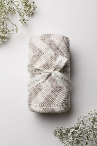 Knitted chevron stripe baby blanket in beige and cream tied with an Isla & Fraser ribbon