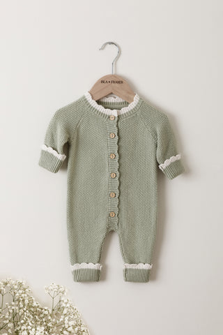 Knitted Baby Romper in Sage with cream tipping on a wooden Isla & Fraser hanger