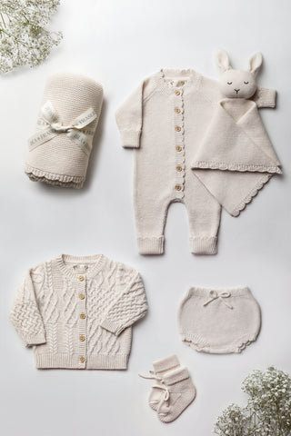 Neutral Knitted Baby Gift Set flatlay: blanket, romper, bunny comforter, cardigan, bloomers, and booties