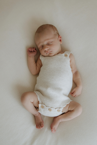Sleeping baby wearing knitted baby romper
