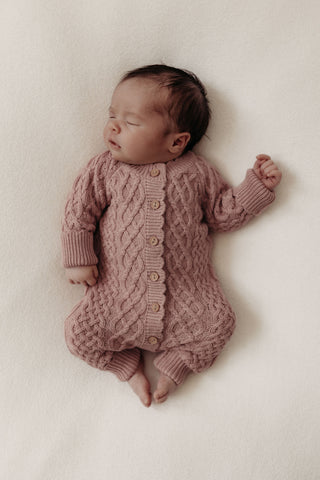 Newborn baby wearing cable knit romper in pink