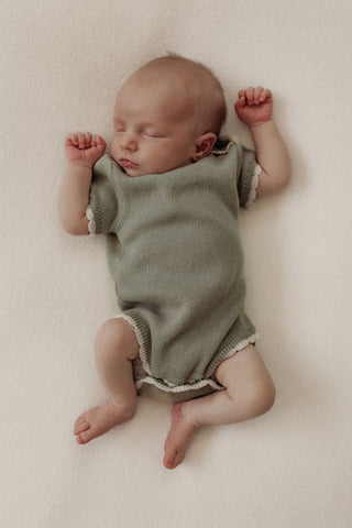 Baby wearing knitted sage bodysuit