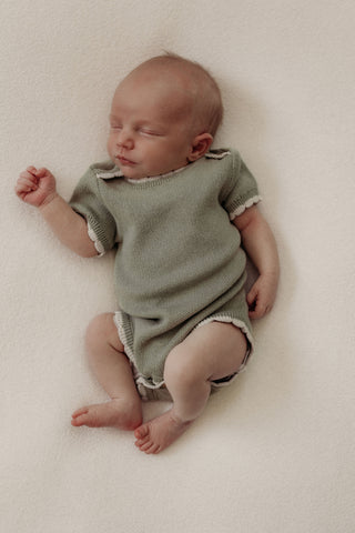 Baby wearing sage bodysuit