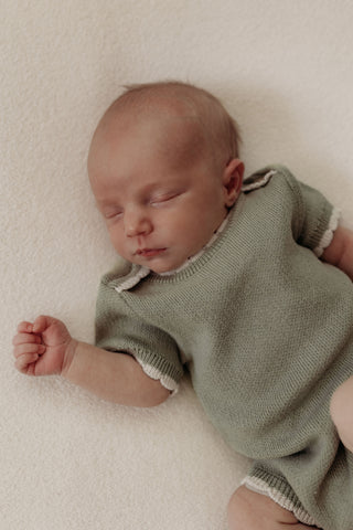 Baby wearing knitted sage bodysuit