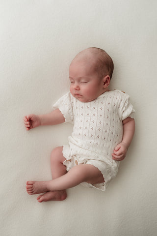 Baby wearing white pointelle bodysuit 