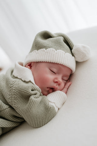 Sleeping baby dressed as a Christmas elf