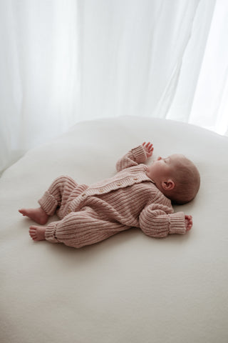 Sleeping baby on beanbag with white sheer curtain