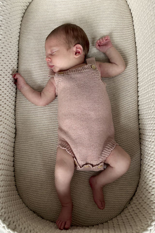 Sleeping newborn in moses basket