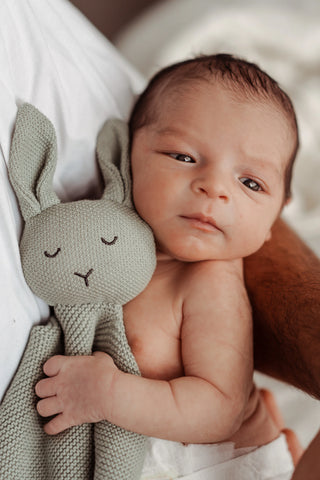 Baby cuddling a Sage Isla & Fraser Bunny Comforter