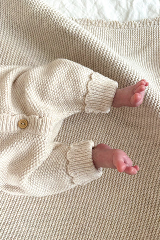 baby feet wearing knitted baby romper