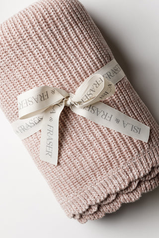 Pink knitted baby blanket with a scalloped edge and tied with an Isla and Fraser ribbon