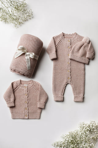 Pink knitted baby blanket, cardigan, romper, and hat