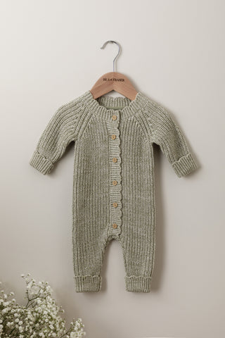 Green knitted baby romper on an Isla & Fraser wooden hanger 