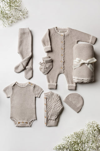 Grey knitted gift set containing clothing and a blanket