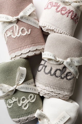 Group of embroidered named baby blankets tied with Isla & Fraser ribbons