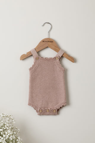Knitted pink baby romper on an Isla & Fraser hanger