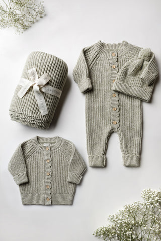 Sage green knitted baby blanket, cardigan, romper and hat.