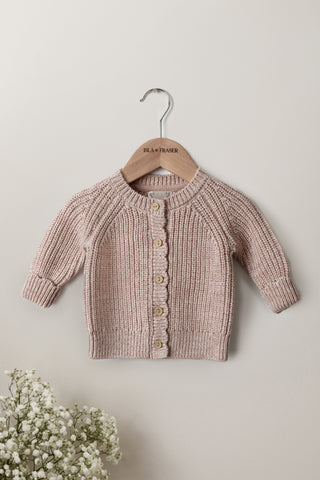 Light pink knitted baby cardigan on a wooden Isla & Fraser hanger 