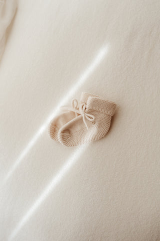 Knitted beige baby bow booties 