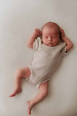Baby wearing grey knitted bodysuit