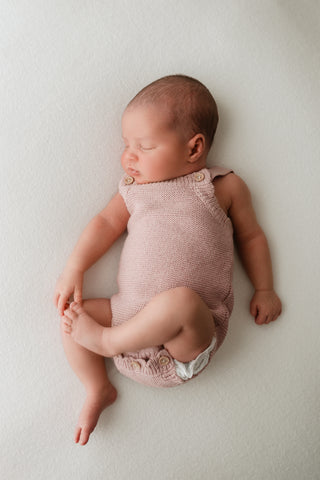 Baby wearing a pink knitted romper