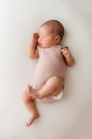 Baby wearing a pink knitted romper