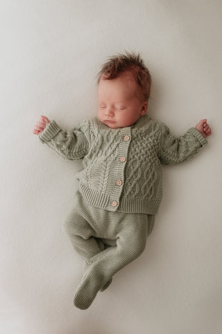 Baby wearing sage green knitted cardigan and leggings