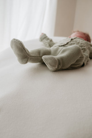 Baby wearing sage green knitted trousers