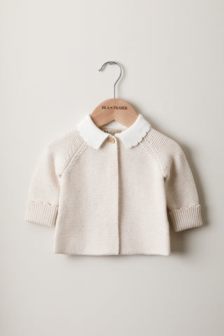 Knitted Baby Cardigan with Scallop Collar on a wooden Isla & Fraser hanger
