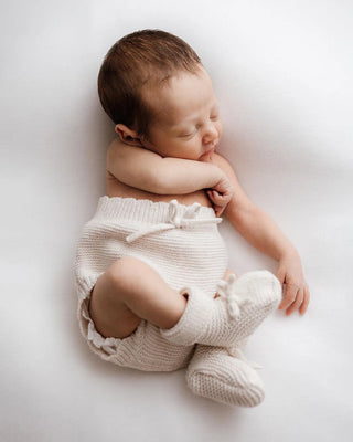 Newborn baby wearing knitted bloomers and booties