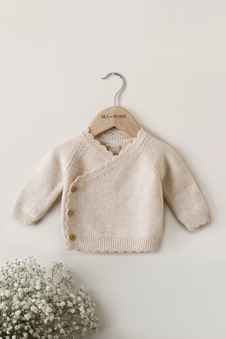 Beige Knitted Baby Wrap Cardigan on a wooden Isla & Fraser hanger