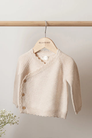Knitted Beige Baby Cardigan on a wooden Isla & Fraser hanger on a wooden pole