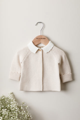 Knitted Baby Cardigan with Scallop Collar on a wooden Isla & Fraser hanger