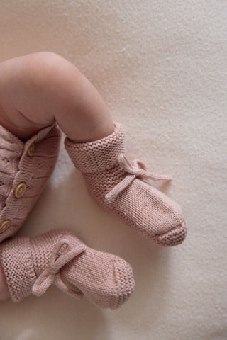 Baby wearing pink knit baby booties