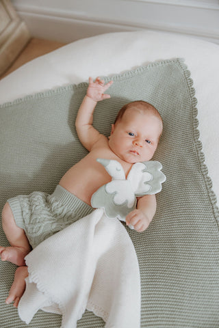 Newborn Baby lying on Sage Baby Blanket  with Knitted Sage Stork Comforter
