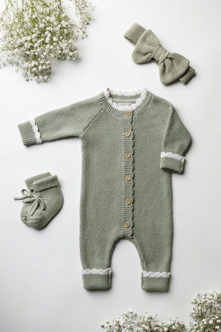 knitted baby outfit in sage green, comprising booties, romper and bow headband.