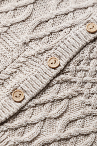 Buttons on a neutral cable knit cardigan