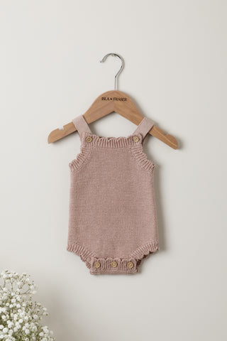 Knitted pink baby romper on an Isla & Fraser hanger
