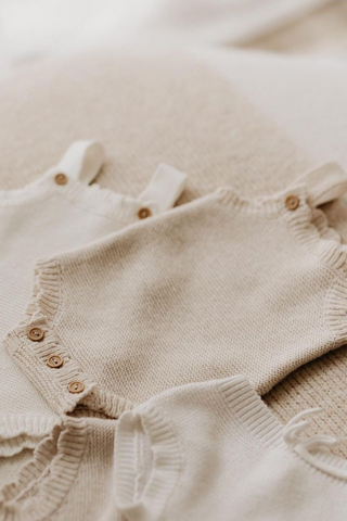 Neutral Baby Knitwear laid on a blanket